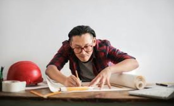 Arsitek pria menggambar di atas kertas